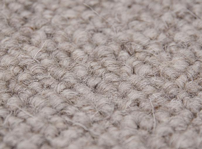 Close-up photo of a gray wool carpet.