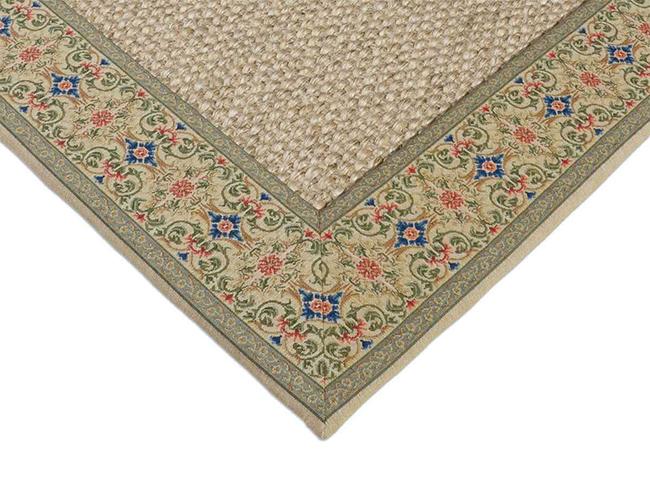 Photo of the corner of a sisal rug with an elaborately sewn patterned border.