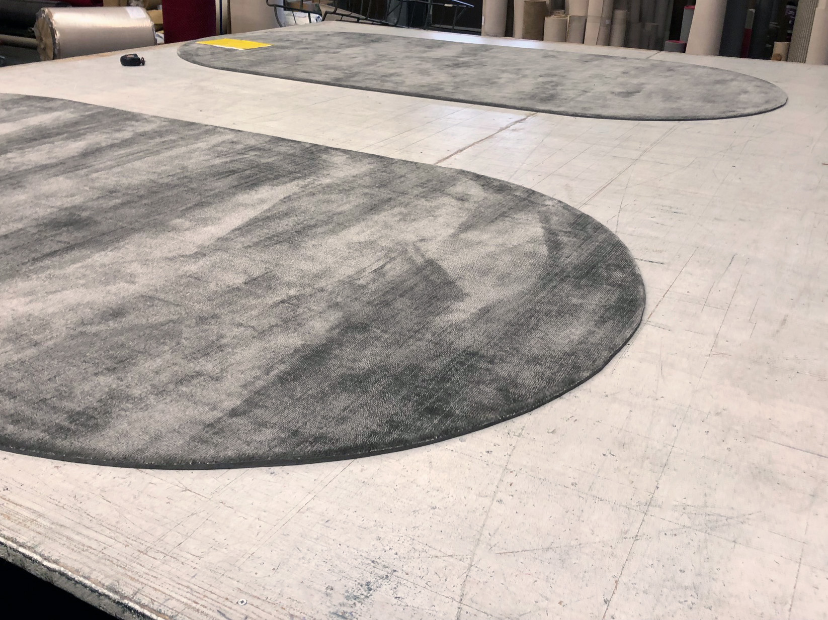 Foto aus der Produktion von zwei speziell angefertigten handgewebten Teppichen.