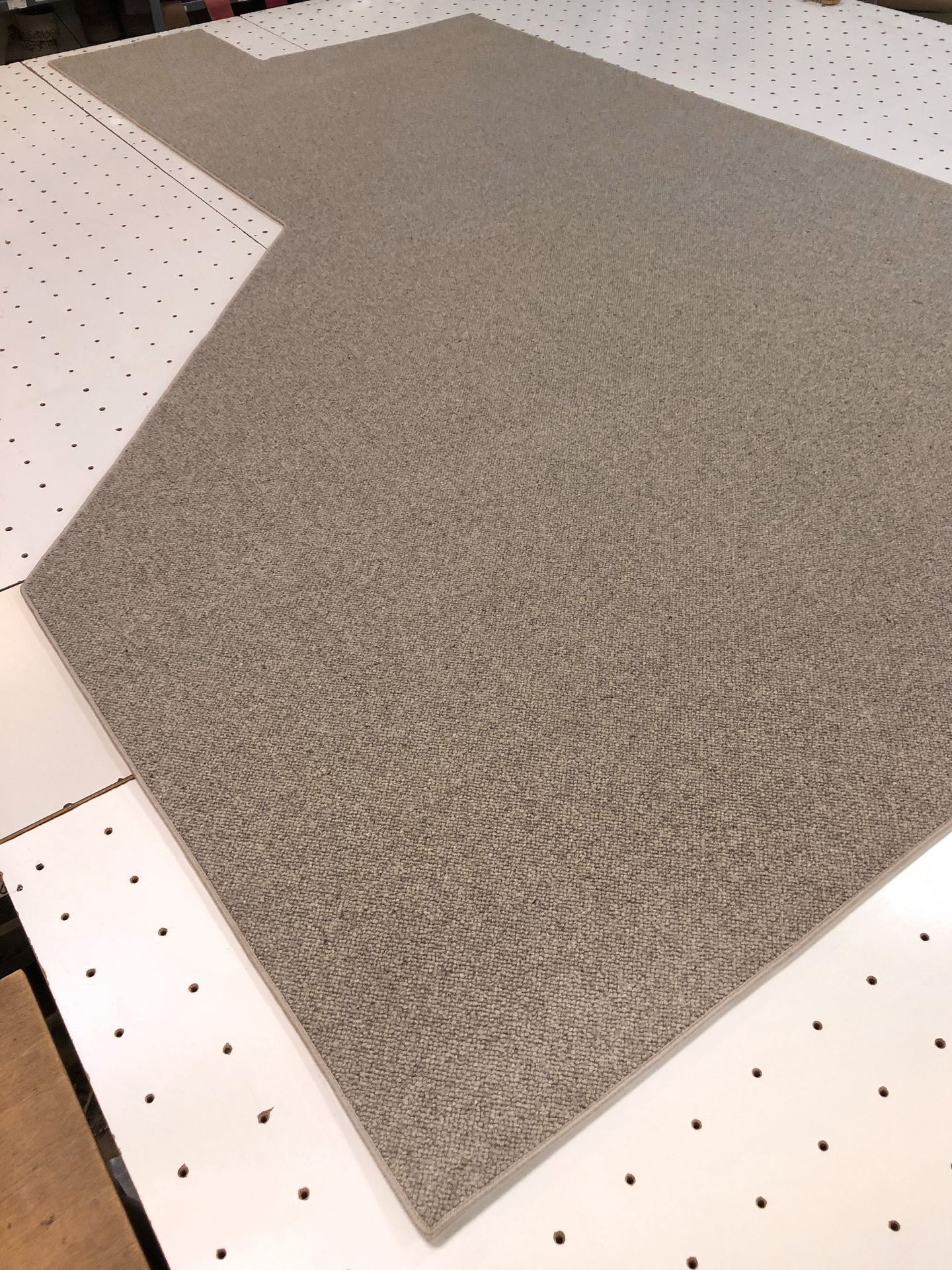 Foto aus der Produktion eines sehr aufwendig nach Schablone gefertigten Teppichs für einen Erkerausschnitt.
