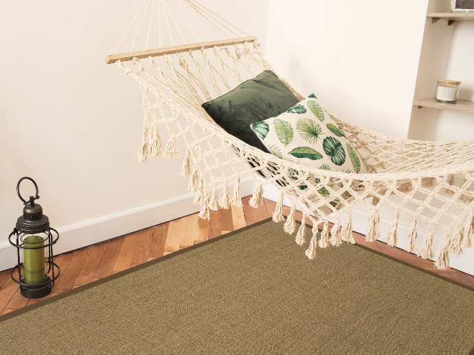 Environment photo of a Purstoff rug in pecan brown under a hammock.