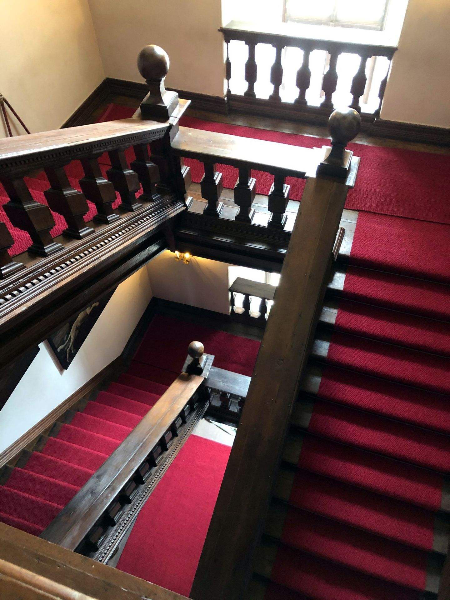 Photo of a wooden staircase in the Anholt moated castle with our red coir runners. 