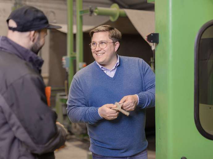 Photo of Mr. Schürholz showing an interested party how environmentally friendly Purstoff is manufactured by Grundstoff.