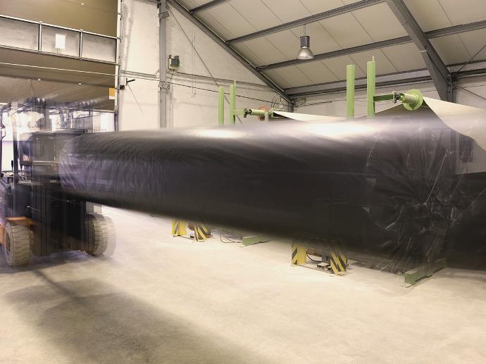 Photo of a forklift with a roll of carpet on a metal thorn.