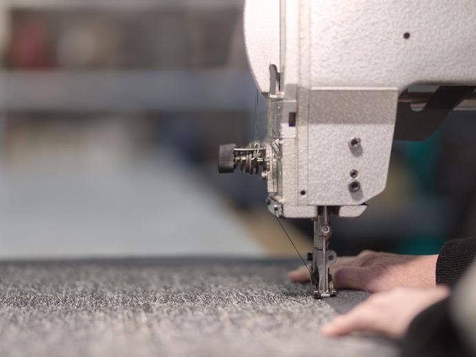 Close-up of how a carpet with a border is sewn in.