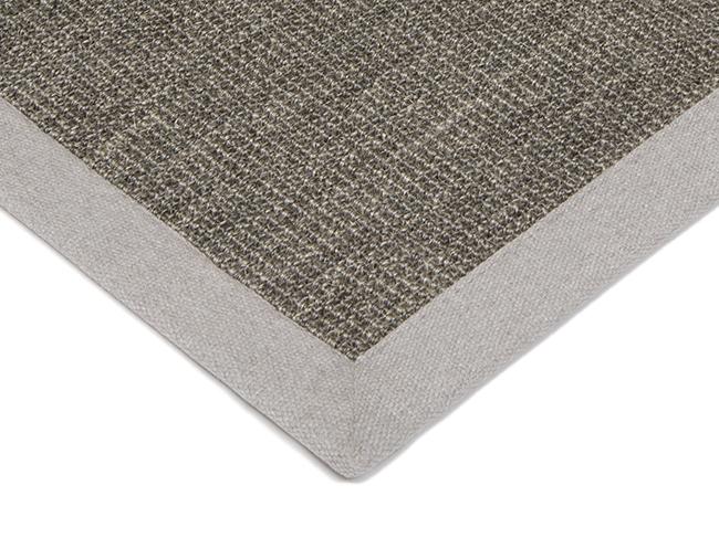 Photo of the corner of a Purstoff sisal rug with a cotton border.