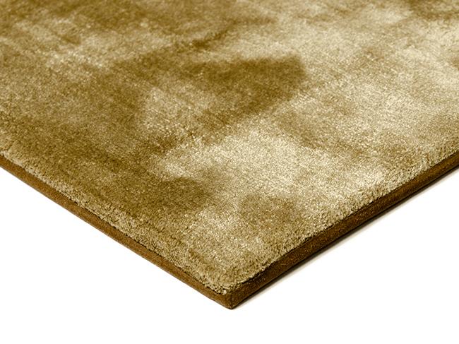 Photo of the corner of a velour rug with a microfiber tape border and shaved edges.