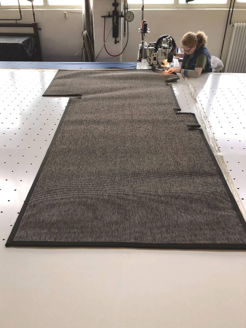 Foto aus der Produktion eines sehr aufwendig nach Schablone gefertigten Teppichs.